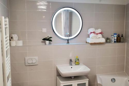 a white bathroom with a sink and a mirror at DN Green apartment in Budapest