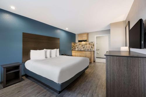 ein Schlafzimmer mit einem großen weißen Bett und einer blauen Wand in der Unterkunft SureStay Hotel by Best Western Spring North Houston in Spring