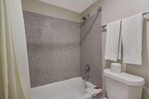 a bathroom with a white toilet and a shower at SureStay Hotel by Best Western Spring North Houston in Spring