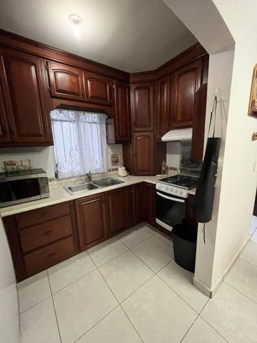 a kitchen with wooden cabinets and a stove top oven at Casa Villa Serena in San Carlos