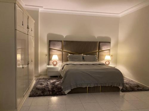 - une chambre avec un grand lit et une tête de lit dans l'établissement Nile View 2-Bed Apartment in Zamalek Cairo, au Caire