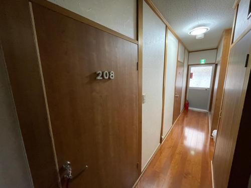 a hallway with a sign on a door at Guest House Hamada-en in Tottori