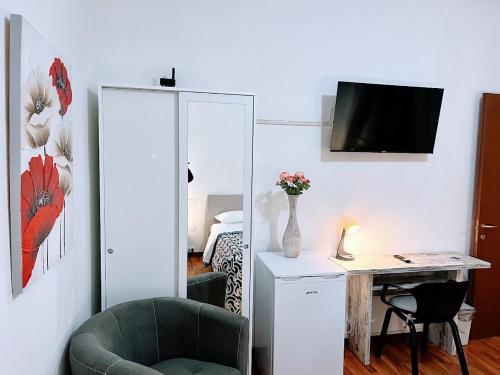 a room with a chair and a desk with a television at Venice Suites in Mestre
