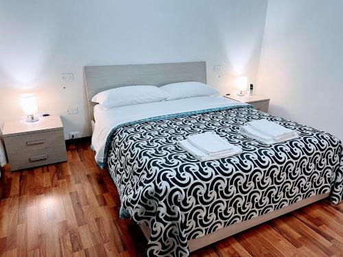 a bedroom with a large bed with a black and white blanket at Venice Suites in Mestre