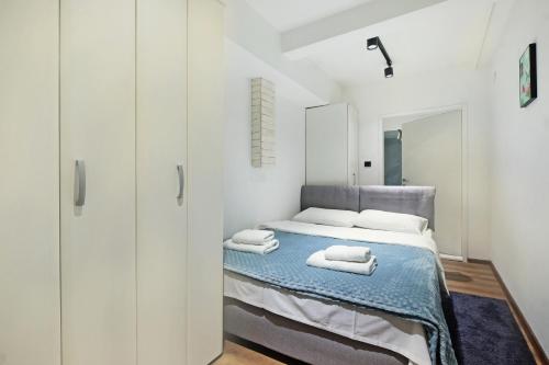 a white bedroom with a bed and a mirror at Apartment Paradise Resavska in Belgrade