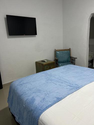 a bedroom with a bed and a tv on the wall at Casa Torices Real 12 in Cartagena de Indias