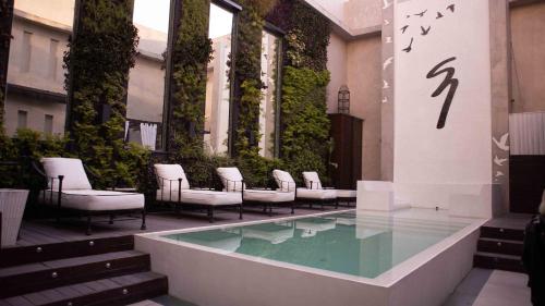a group of chairs and a pool in a building at 1828 Smart Hotel Boutique in Buenos Aires