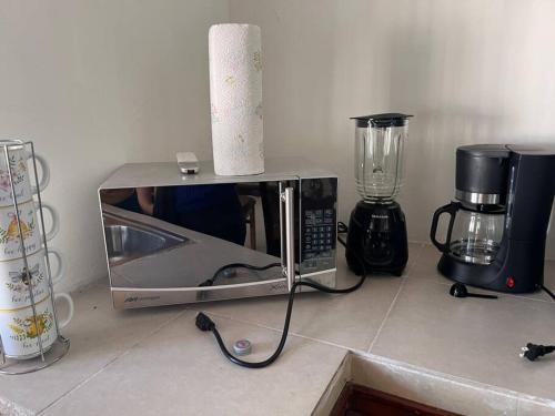 a microwave sitting on a counter next to a blender at Flores Condominios Depa Lili in Álamos