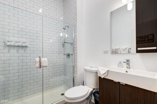a bathroom with a toilet and a sink and a shower at River West, Third Floor Chicago by 747 Lofts in Chicago