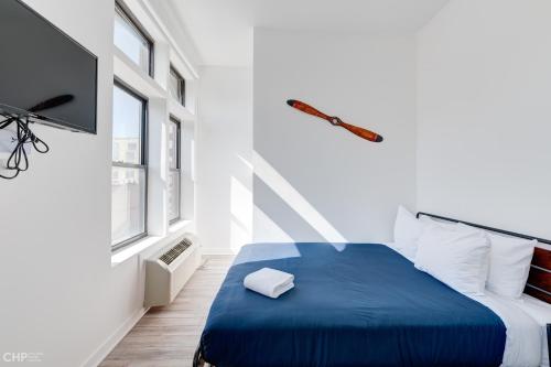 a bedroom with a blue bed and a tv at Chicago Second Floor Studio by 747 Lofts in Chicago
