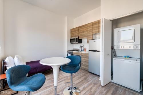 a kitchen with a table and two blue chairs in a room at Chicago Third Floor Studio by 747 Lofts in Chicago