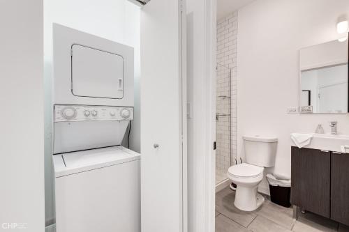 een witte badkamer met een toilet en een wastafel bij Chicago Third Floor Studio by 747 Lofts in Chicago