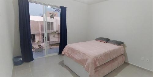 um quarto com uma cama e uma grande janela em La Ceiba em Playa del Carmen