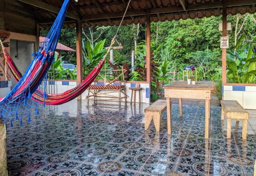 a patio with a hammock and a table and chairs at La Katalinda in Drake
