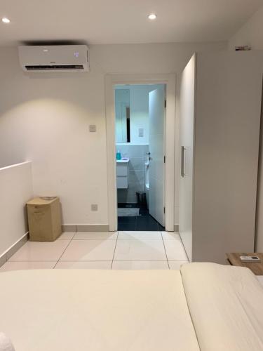 a white room with a bathroom and a hallway at RT properties @ The gardens in Accra