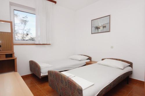 dwa łóżka w pokoju z dwoma oknami w obiekcie Apartments by the sea Razanac, Zadar - 5766 w Ražancu