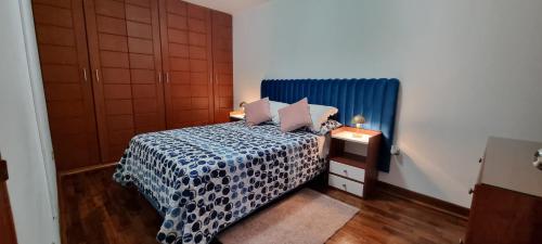 1 dormitorio con 1 cama con colcha azul y blanca en APARTAMENTO DE 3 DORMITORIOS EN LA MOLINA, en Lima