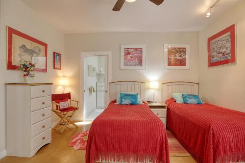 2 bedden in een slaapkamer met rode lakens en blauwe kussens bij 1460 Strand Way in Oceano