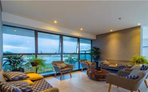 sala de estar con muebles y ventana grande en Ezza in Barra - Beach Flat, en Recife