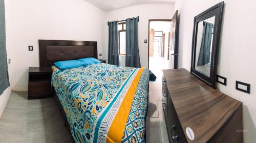 a bedroom with a bed and a dresser and a mirror at Villa Don Pedro - Casa de descanso in San Pedro La Laguna