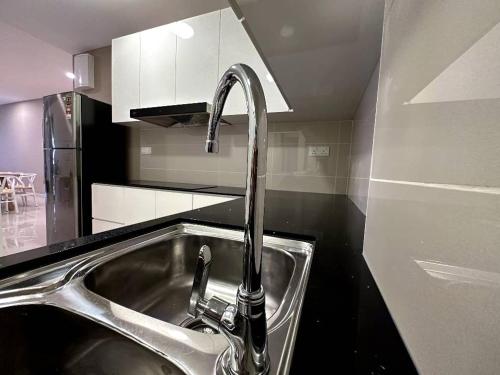 a kitchen sink with a faucet in a kitchen at The Apple PREMIER CONDO three bedroom in MELAKA in Malacca