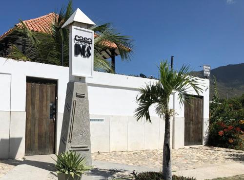 a sign in front of a white building with a palm tree at Casa Ines in Santa Marta