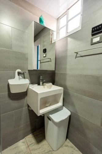 a bathroom with a sink and a toilet and a mirror at Amazing Apartments, A-Juan Dolio, El Bonito II in Juan Dolio