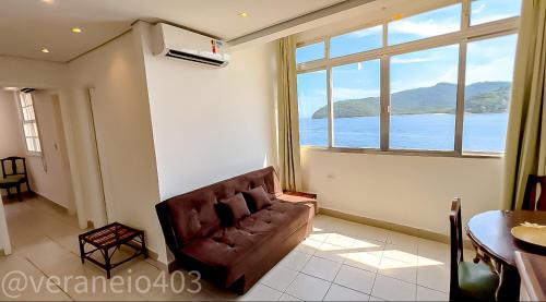 - un salon avec un canapé et une grande fenêtre dans l'établissement Apartamento frente mar c/ar P/ 6 hóspedes, à São Vicente