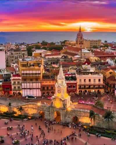 a view of a city at sunset with a clock tower at Casa Torices Real 12 in Cartagena de Indias