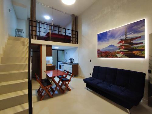 sala de estar con sofá negro y mesa en GUARATUBA LOFTS, en Guaratuba