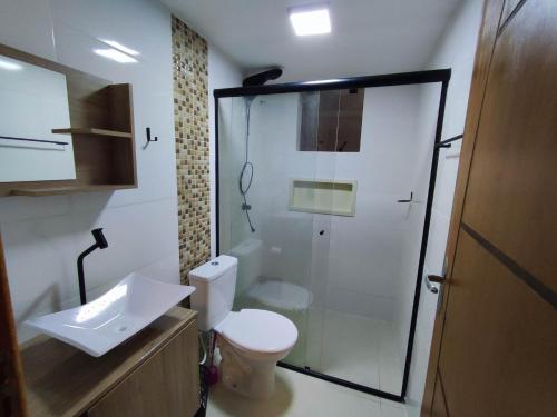 a bathroom with a shower and a toilet and a sink at GUARATUBA LOFTS in Guaratuba