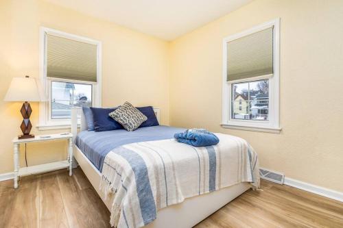 ダビュークにあるOaklie's Bungalow - Charming Home in Dubuqueのベッドルーム1室(ベッド1台、窓2つ付)