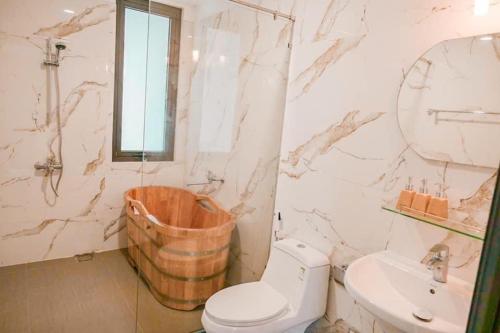 a bathroom with a tub and a toilet and a sink at The Bright House Villa - Venuestay in Hanoi