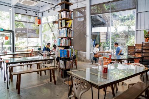 un grupo de personas sentadas en mesas en una biblioteca en 秀川居 Xiuchuanju en Sanxia