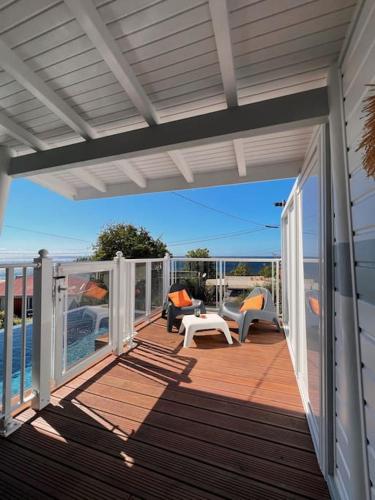 an open deck with chairs and a table on a house at Villa MauCa in Pointe-Noire