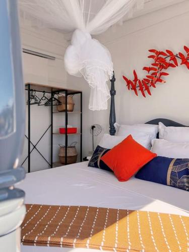 1 dormitorio con 1 cama con almohadas rojas y azules en Villa MauCa, en Pointe-Noire