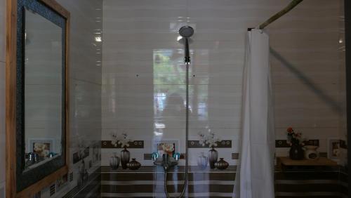 Zimmer mit einer Dusche mit Vasen und einem Fenster in der Unterkunft Nha Tan - Mai Chau Homestay and Tours in Mai Châu