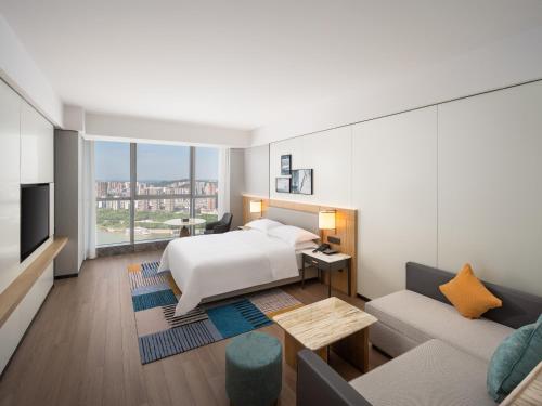 ein Hotelzimmer mit einem Bett und einem Sofa in der Unterkunft Hyatt Place Nanchong Gaoping in Nanchong