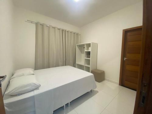 sypialnia z białym łóżkiem i szafką w obiekcie Casa céu de estrelas w mieście Arraial d'Ajuda