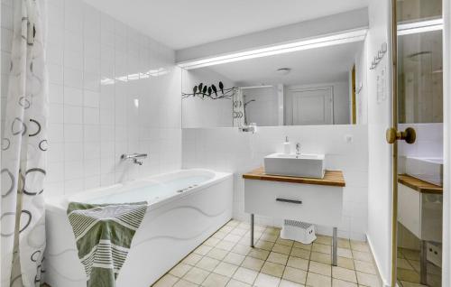 a white bathroom with a tub and a sink at 3 Bedroom Amazing Apartment In Nykbing Sj in Rørvig