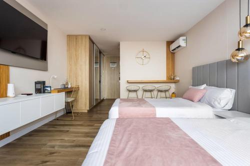 Habitación de hotel con 2 camas y cocina en Suite - Go living & Suites, en Medellín