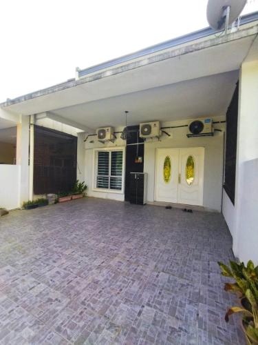 a garage with a brick floor and white doors at D'Indah59 KLIA Homestay in Sepang