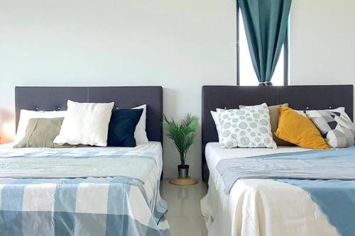 twee bedden naast elkaar in een slaapkamer bij Ipoh Meru Landed Semi D - Barbeque & Pool for 12 Pax in Ipoh