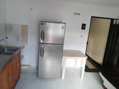 a kitchen with a stainless steel refrigerator and a table at hotel Valery in San Gil