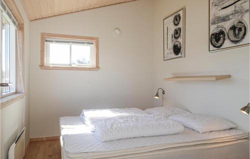Cama blanca en habitación con ventana en 2 Bedroom Stunning Home In Gudhjem, en Gudhjem