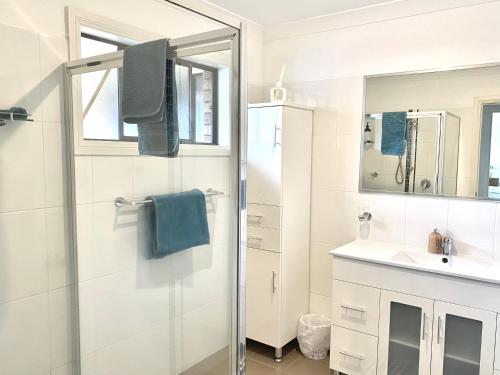 y baño con ducha y lavamanos. en Bermagui Beach Apartment, en Bermagui