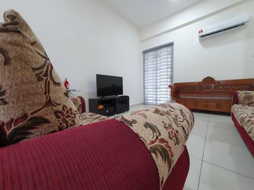 a living room with a couch and a flat screen tv at 3Storey House 13Pax Family Suite in Bayan Lepas