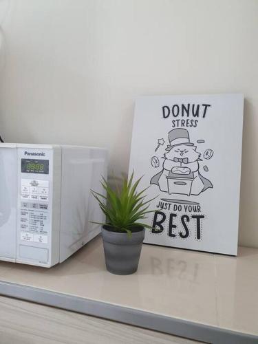 a dont stress just do your best sign next to a microwave at 3Storey House 13Pax Family Suite in Bayan Lepas