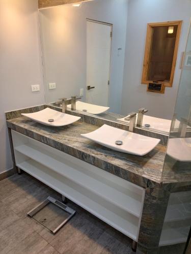 a bathroom with two sinks and a large mirror at Silver Inn Hotel in Cerro Azul
