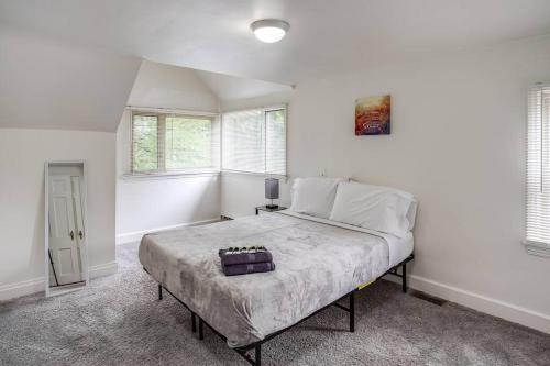 a bedroom with a large bed in a room with windows at ~Hot Tub~ in a Quiet Home near UofR/Dwnt/Aiprt/RIT in Rochester